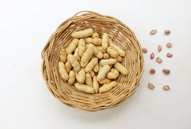 Organik fıstık, kabuklu ve haşlanmış fıstık, amendoim cozido, serpe, nordeste, Brezilya (Arachis hipogaea L.) Tahta bir sepette, beyaz bir sırt damlasında izole edilmiş.