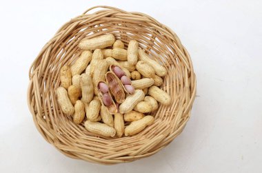 Organik fıstık, kabuklu ve haşlanmış fıstık, amendoim cozido, serpe, nordeste, Brezilya (Arachis hipogaea L.) Tahta bir sepette, beyaz bir sırt damlasında izole edilmiş.