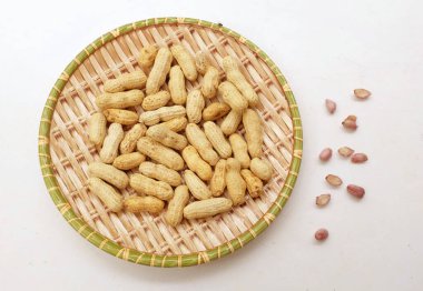 Organik fıstık, kabuklu ve haşlanmış fıstık, amendoim cozido, serpe, nordeste, Brezilya (Arachis hipogaea L.), beyaz bir sırt damlasının üzerindeki ahşap tepside.