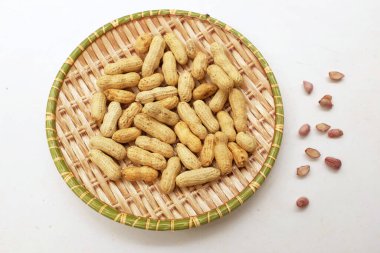 Organik fıstık, kabuklu ve haşlanmış fıstık, amendoim cozido, serpe, nordeste, Brezilya (Arachis hipogaea L.), beyaz bir sırt damlasının üzerindeki ahşap tepside.