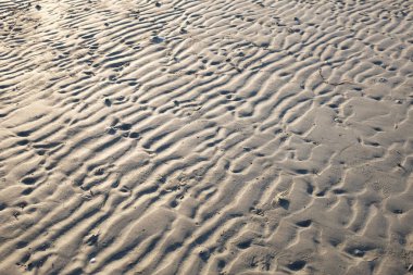Doğal dalga desenli kumsal koyu kahverengi arka plan. Kum dokusu arkaplan duvar kağıdı rüzgar dalgaları, nehir kıyısı sahili plajı bej doğal kum soyut