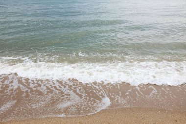 Yumuşak kuma düşen dalgaların güzel fotoğrafları. Canlı renkler bu tropikal paradisin huzur ve güzelliğini vurguluyor. Tatil temaları, seyahat ve rahatlama resimleri tasarlamayı düşünüyor.