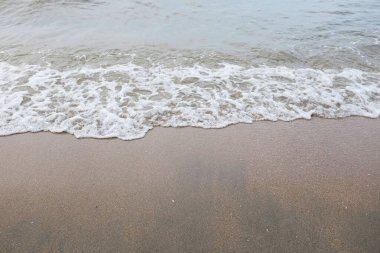 Yumuşak kuma düşen dalgaların güzel manzara fotoğrafları. Canlı renkler bu tropikal paradisin huzur ve güzelliğini vurguluyor. Tatil temaları, seyahat ve rahatlama resimleri tasarlamayı düşünüyor.