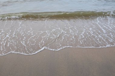 Yumuşak kuma düşen dalgaların güzel manzara fotoğrafları. Canlı renkler bu tropikal paradisin huzur ve güzelliğini vurguluyor. Tatil temaları, seyahat ve rahatlama resimleri tasarlamayı düşünüyor.