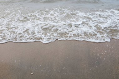 Yumuşak kuma düşen dalgaların güzel manzara fotoğrafları. Canlı renkler bu tropikal paradisin huzur ve güzelliğini vurguluyor. Tatil temaları, seyahat ve rahatlama resimleri tasarlamayı düşünüyor.