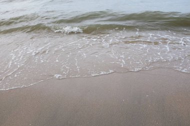 Yumuşak kuma düşen dalgaların güzel manzara fotoğrafları. Canlı renkler bu tropikal paradisin huzur ve güzelliğini vurguluyor. Tatil temaları, seyahat ve rahatlama resimleri tasarlamayı düşünüyor.