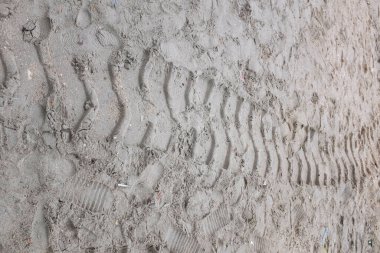 Kumsaldaki lastik izlerinin dokusunda yukarıdan panorama manzarası. Kum aracının kahverengi tekerlek şeklindeki lastik izleri.