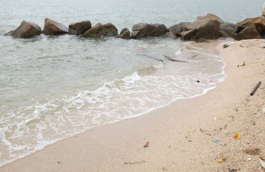 Mavi bir okyanus dalgalarının güzel manzarası sahildeki kayalara sertçe çarptı. Kayalara püskürtüldü. Taşlara su sıçrıyor. Bangsaen, Chonburi Tayland 'dan bir sahil fotoğrafı.