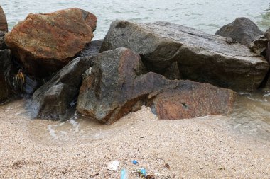 Mavi bir okyanus dalgalarının güzel manzarası sahildeki kayalara sertçe çarptı. Kayalara püskürtüldü. Taşlara su sıçrıyor. Bangsaen, Chonburi Tayland 'dan bir sahil fotoğrafı.
