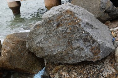Mavi bir okyanus dalgalarının güzel manzarası sahildeki kayalara sertçe çarptı. Kayalara püskürtüldü. Taşlara su sıçrıyor. Bangsaen, Chonburi Tayland 'dan bir sahil fotoğrafı.