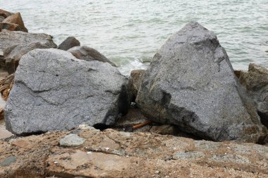 Mavi bir okyanus dalgalarının güzel manzarası sahildeki kayalara sertçe çarptı. Kayalara püskürtüldü. Taşlara su sıçrıyor. Bangsaen, Chonburi Tayland 'dan bir sahil fotoğrafı.