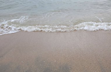 Yumuşak kuma düşen dalgaların güzel manzara fotoğrafları. Canlı renkler bu tropikal paradisin huzur ve güzelliğini vurguluyor. Tatil temaları, seyahat ve rahatlama resimleri tasarlamayı düşünüyor.