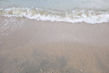 Yumuşak kuma düşen dalgaların güzel manzara fotoğrafları. Canlı renkler bu tropikal paradisin huzur ve güzelliğini vurguluyor. Tatil temaları, seyahat ve rahatlama resimleri tasarlamayı düşünüyor.