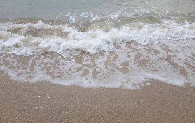 Yumuşak kuma düşen dalgaların güzel manzara fotoğrafları. Canlı renkler bu tropikal paradisin huzur ve güzelliğini vurguluyor. Tatil temaları, seyahat ve rahatlama resimleri tasarlamayı düşünüyor.