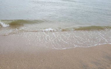 Yumuşak kuma düşen dalgaların güzel manzara fotoğrafları. Canlı renkler bu tropikal paradisin huzur ve güzelliğini vurguluyor. Tatil temaları, seyahat ve rahatlama resimleri tasarlamayı düşünüyor.