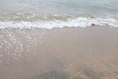 Yumuşak kuma düşen dalgaların güzel manzara fotoğrafları. Canlı renkler bu tropikal paradisin huzur ve güzelliğini vurguluyor. Tatil temaları, seyahat ve rahatlama resimleri tasarlamayı düşünüyor.