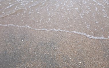 Yumuşak kuma düşen dalgaların güzel manzara fotoğrafları. Canlı renkler bu tropikal paradisin huzur ve güzelliğini vurguluyor. Tatil temaları, seyahat ve rahatlama resimleri tasarlamayı düşünüyor.