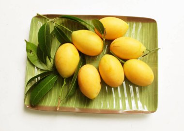  Taze, olgun Marian eriği Thai meyvesi tepsilerde izole edilmiş beyaz bir zemin üzerinde (mayongchid maprang marian eriği ve erik mangosu, thailand). Tayland 'ın sağlıklı meyveleri