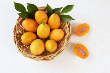  Taze, olgun Marian eriği Tayland meyvesi sepeti içinde beyaz bir zemin üzerinde izole edilmiş bir sepette (mayongchid maprang marian eriği ve erik mangosu, thailand). Tayland 'ın sağlıklı meyveleri