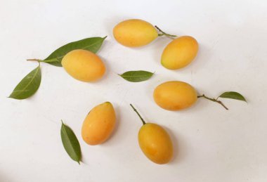 Üst ve düz taze tatlı olgun Marian eriği yığını Tayland meyvesi beyaz bir zemin üzerinde izole (mayongchid maprang marian erik ve erik mango, thailand). Tayland 'ın sağlıklı meyveleri