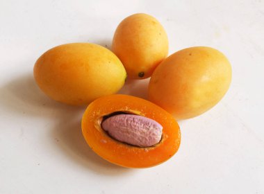 Üst ve düz taze tatlı olgun Marian eriği yığını Tayland meyvesi beyaz bir zemin üzerinde izole (mayongchid maprang marian erik ve erik mango, thailand). Tayland 'ın sağlıklı meyveleri