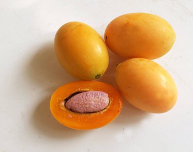 Üst ve düz taze tatlı olgun Marian eriği yığını Tayland meyvesi beyaz bir zemin üzerinde izole (mayongchid maprang marian erik ve erik mango, thailand). Tayland 'ın sağlıklı meyveleri