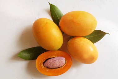 Üst ve düz taze tatlı olgun Marian eriği yığını Tayland meyvesi beyaz bir zemin üzerinde izole (mayongchid maprang marian erik ve erik mango, thailand). Tayland 'ın sağlıklı meyveleri