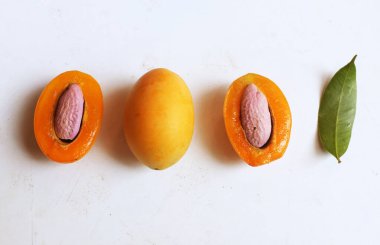 Üst ve düz taze tatlı olgun Marian eriği yığını Tayland meyvesi beyaz bir zemin üzerinde izole (mayongchid maprang marian erik ve erik mango, thailand). Tayland 'ın sağlıklı meyveleri