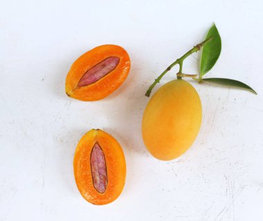 Üst ve düz taze tatlı olgun Marian eriği yığını Tayland meyvesi beyaz bir zemin üzerinde izole (mayongchid maprang marian erik ve erik mango, thailand). Tayland 'ın sağlıklı meyveleri