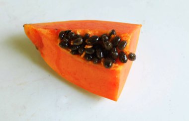 Üst ve düz taze, olgun bir papaya meyvesi uzanıyor. Tohumları, yemek dokusunu, kesimini, kesilmiş meyveleri beyaz bir zeminde izole edilmiş. Sağlıklı beslenme için sebze ve meyve.
