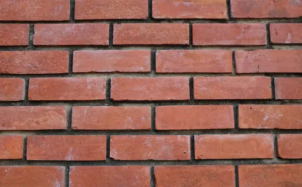 Turuncu duvara kırmızı boya sıçramış, kırmızı taş blokların zemini, eski tuğla duvarın arka planı, eski tuğla evin arka planı, kırmızı tuğla arka plan dokusu ve deseni. Tasarım için boş alan 