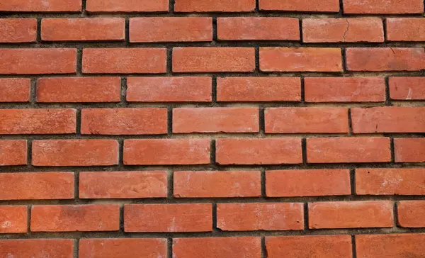 Turuncu duvara kırmızı boya sıçramış, kırmızı taş blokların zemini, eski tuğla duvarın arka planı, eski tuğla evin arka planı, kırmızı tuğla arka plan dokusu ve deseni. Tasarım için boş alan 