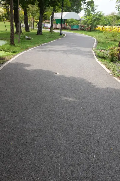 Pitty 'nin yatay görüntüsü asfalt yol, patika ya da yürüyüş yolu. Tayland' daki halk parkında güzel doğal ağaçlarla koşmak ve yürümek için. Konsept rahatlama içeriyor.,