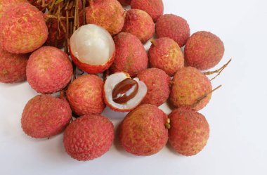 Yığınla taze taze, sulu kırmızı liçi, litçi, liçi meyveleri (litchi chinensis sonn). Tüm liçi ve ikiye bölünmüş yeşil yaprak beyaz bir zemin üzerinde izole edilmiş.