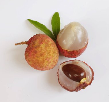 Yığınla taze taze, sulu kırmızı liçi, litçi, liçi meyveleri (litchi chinensis sonn). Tüm liçi ve ikiye bölünmüş yeşil yaprak beyaz bir zemin üzerinde izole edilmiş.