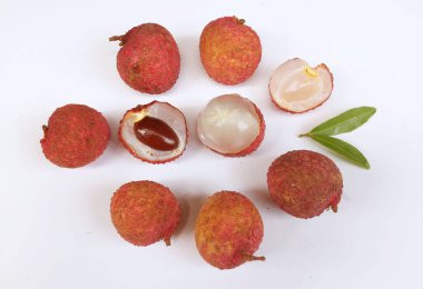 Yığınla taze taze, sulu kırmızı liçi, litçi, liçi meyveleri (litchi chinensis sonn). Tüm liçi ve ikiye bölünmüş yeşil yaprak beyaz bir zemin üzerinde izole edilmiş.
