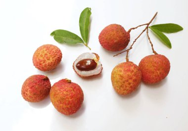 Yığınla taze taze, sulu kırmızı liçi, litçi, liçi meyveleri (litchi chinensis sonn). Tüm liçi ve ikiye bölünmüş yeşil yaprak beyaz bir zemin üzerinde izole edilmiş.