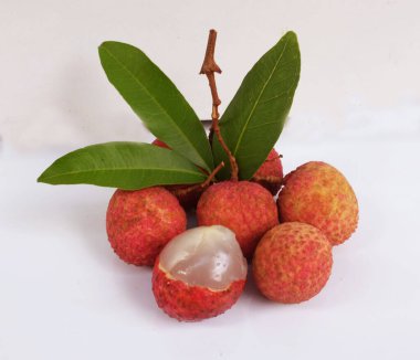 Taze taze tatlı sulu kırmızı liçi, litçi, liçi meyveleri (litchi chinensis sonn.) Tüm liçi ve ikiye bölünmüş yeşil yaprak beyaz bir zemin üzerinde izole edilmiş.