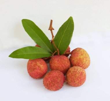 Taze taze tatlı sulu kırmızı liçi, litçi, liçi meyveleri (litchi chinensis sonn.) Tüm liçi ve ikiye bölünmüş yeşil yaprak beyaz bir zemin üzerinde izole edilmiş.