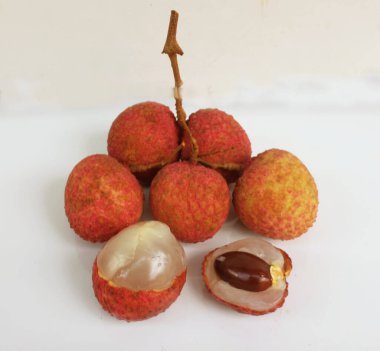 Taze taze tatlı sulu kırmızı liçi, litçi, liçi meyveleri (litchi chinensis sonn.) Tüm liçi ve ikiye bölünmüş yeşil yaprak beyaz bir zemin üzerinde izole edilmiş.