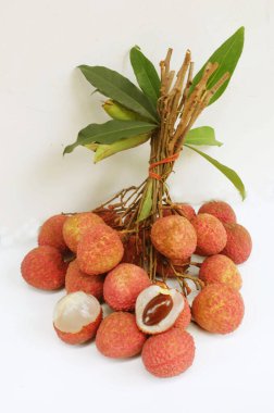 Taze taze tatlı sulu kırmızı liçi, litçi, liçi meyveleri (litchi chinensis sonn.) Tüm liçi ve ikiye bölünmüş yeşil yaprak beyaz bir zemin üzerinde izole edilmiş.