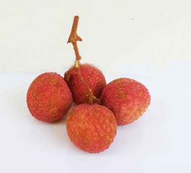 Taze taze tatlı sulu kırmızı liçi, litçi, liçi meyveleri (litchi chinensis sonn.) Tüm liçi ve ikiye bölünmüş yeşil yaprak beyaz bir zemin üzerinde izole edilmiş.