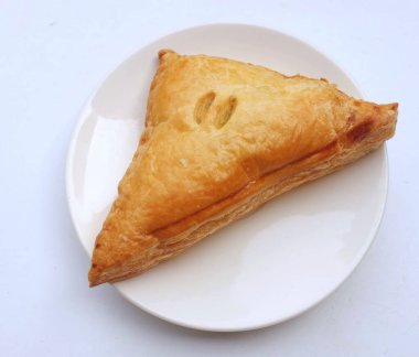  Bir üçgen tavuk turtası, beyaz bir arka planda beyaz bir tabakta izole edilmiş.