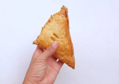 Asyalı bir kadının ellerinde, beyaz bir arka planda izole edilmiş üçgen tavuklu turta..