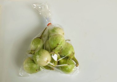 Tayland patlıcan, yeşil brinjal (solanum virginianum l) Net plastik torbada beyaz bir sırt üstü izole edilir. Sağlıklı meyve ve sebze kavramları