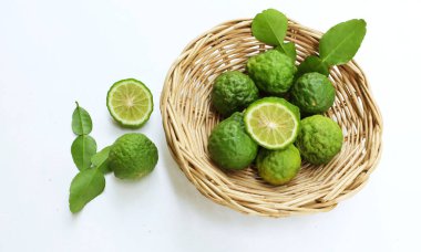 Üst ve düz kaffir kireç, limon, mauritius papida (citrus hystrix dc.) Beyaz arka plandaki bambu sepetinde. Güneydoğu Asya 'ya özgü narenciye bitkisi.