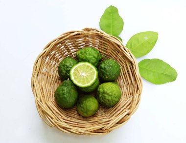 Üst ve düz kaffir kireç, limon, mauritius papida (citrus hystrix dc.) Beyaz arka plandaki bambu sepetinde. Güneydoğu Asya 'ya özgü narenciye bitkisi.