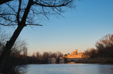 Zamora old town seen form Douro river, Acenas and stone bridge in the foreground, Cathedral in background, Spain