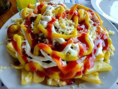 Papas locas, deli patatesler, Kanarya Adaları 'nda patates, mayonez, hardal, ketçap, peynir ve sosis ile çakırkeyif yemek. La Palma Adası, İspanya