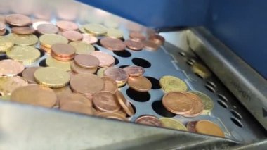 Bir döviz makinesinde sayılacak bir filtreyi geçen Avrupa sikkeleri